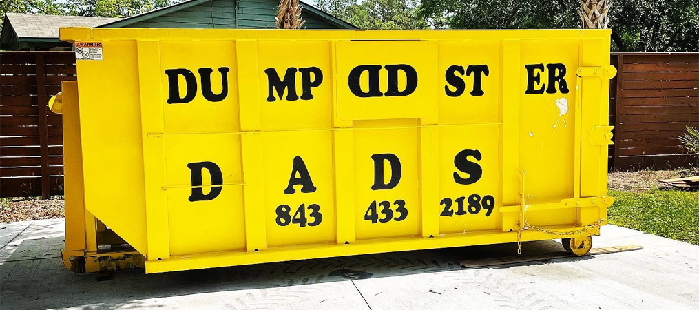 Yellow dumpster for Charleston dumpster rental at a residential property