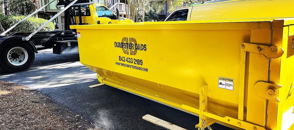 Yellow yard debris dumpster rental in Charleston, SC, delivered to a residential property